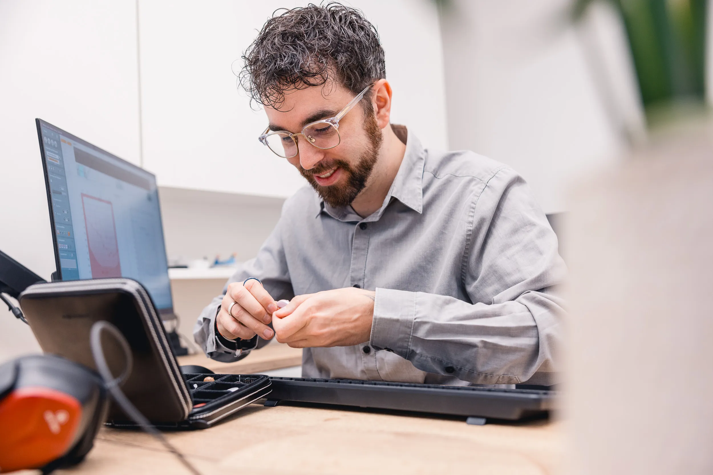 Techniker montiert Elektronik am Arbeitsplatz neben Monitor im Büro